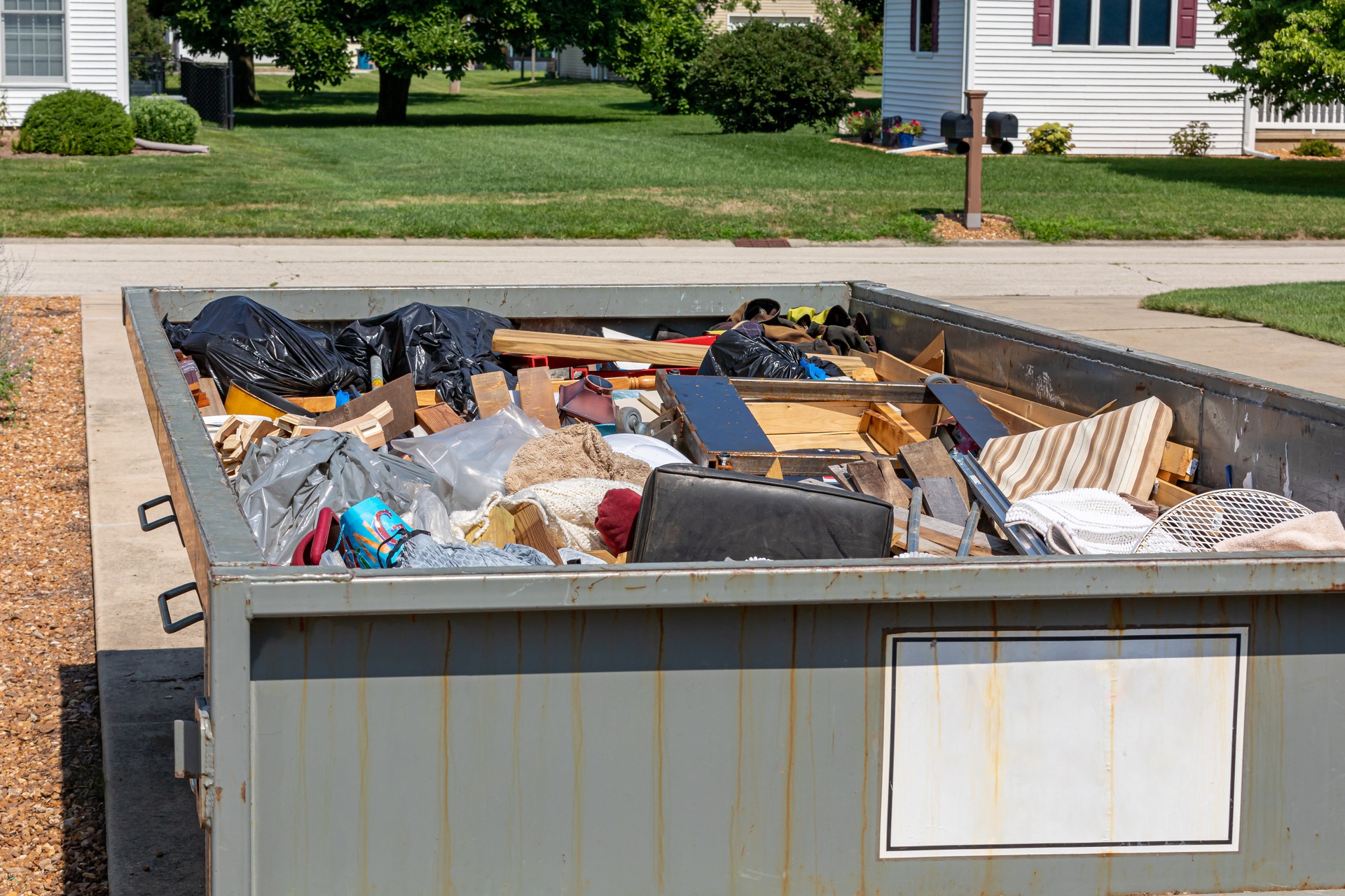 Garbage, trash or waste dumpster full of household junk. House cleaning, declutter and hoarding concept.